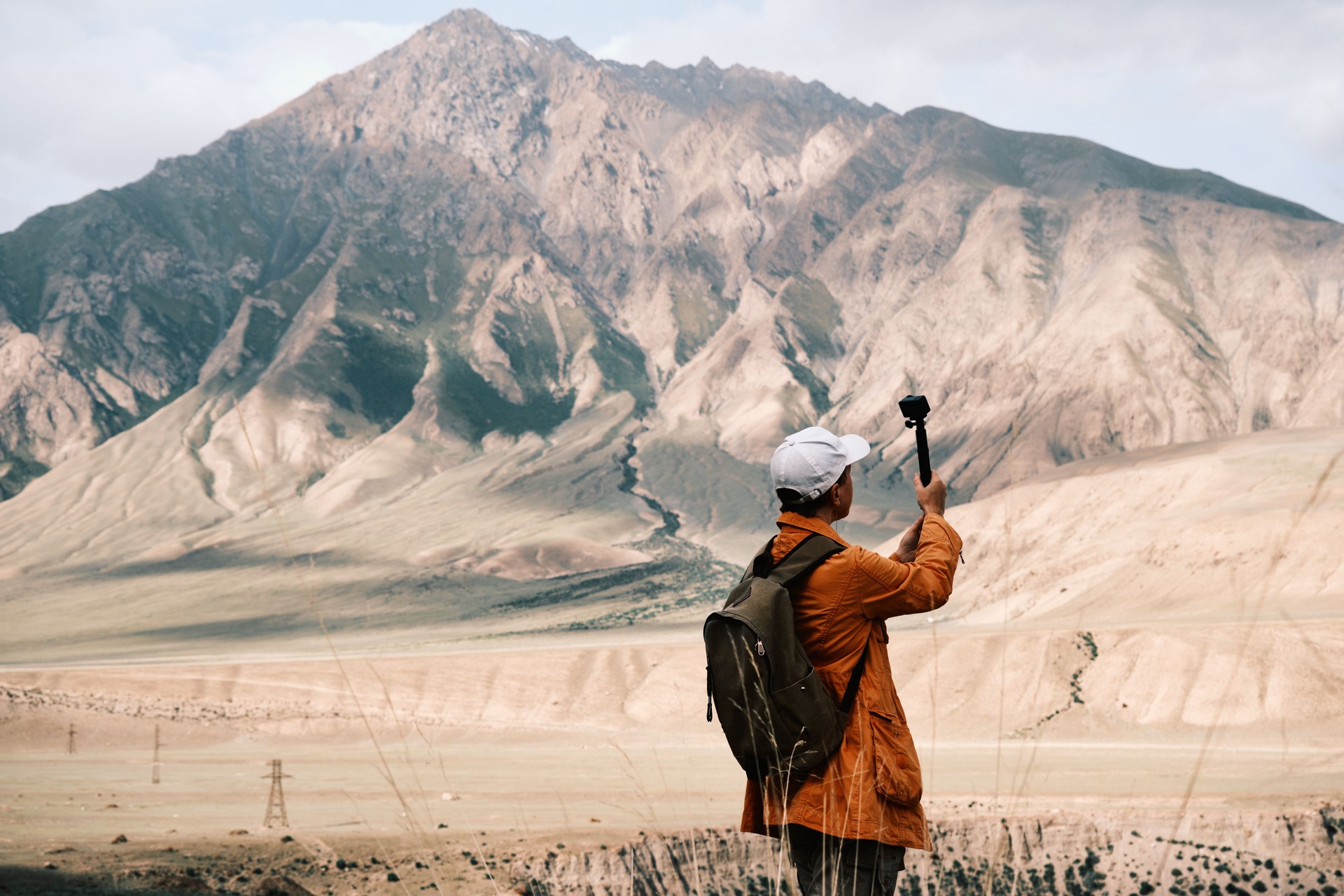 Hiking woman of 47 is using action camera in majestic canyon